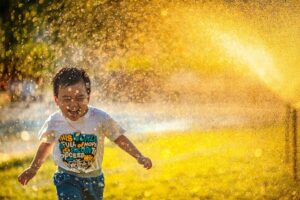 Happy boy running through water. Neurofeedback edinburgh